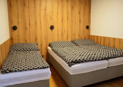 Lůžková část apartmánu s manželskou postelí a 2 oddělenými postelemi