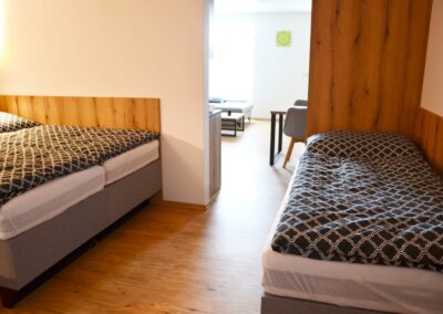 Lůžková část apartmánu s manželskou postelí a 2 oddělenými postelemi